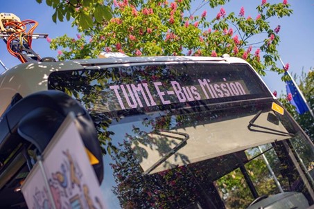 Nahaufnahme eines Elektrobusses, in dessen digitaler Anzeige „TUMI E-Bus Mission“ steht. © TUMI