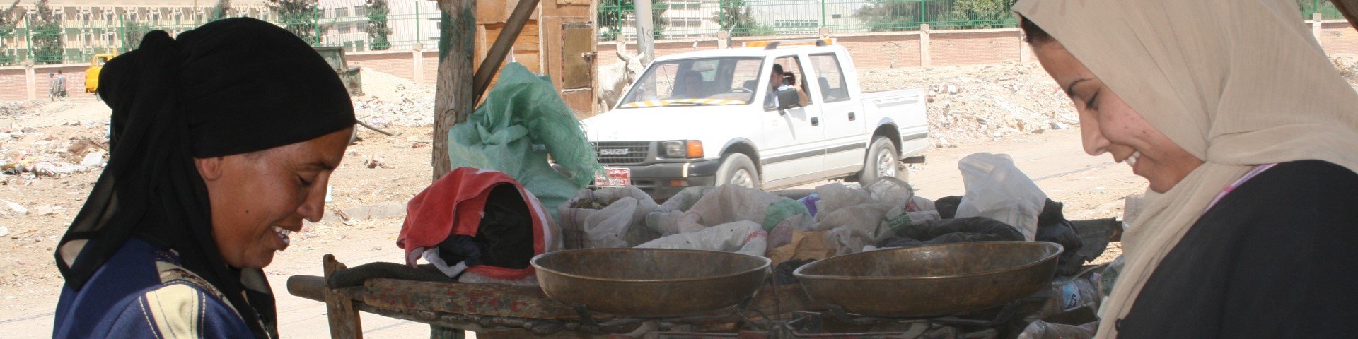 Zwei Frauen bereiten eine Mahlzeit an einem Straßenstand zu.