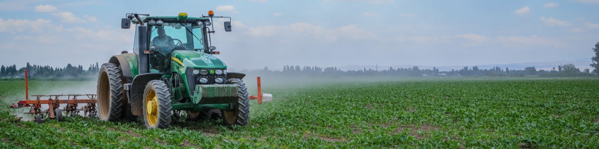Ein Traktor bewässert ein landwirtschaftlich genutztes Feld.