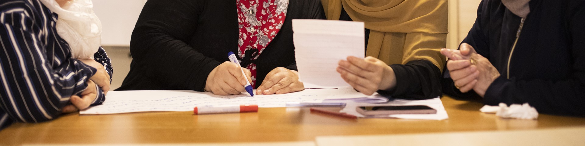 Eine Gruppe von Frauen, die solidarisch zusammenarbeitet und Papiere beschriftet. Copyright: GIZ / Ali Saltan