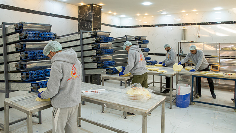 Männer arbeiten in der Produktionshalle eines Kleinunternehmens.