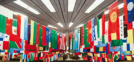 Ein Raum mit einer Vielzahl von internationalen Flaggen, die von der Decke hängen.