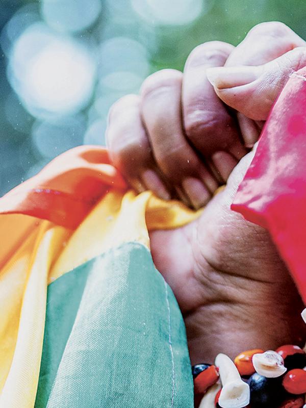 Eine geballte Faust mit der Regenbogenfahne in der Hand