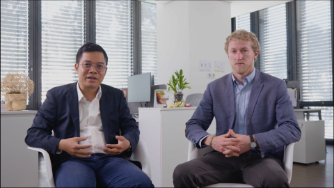 2 people sitting and 1 of them is talking