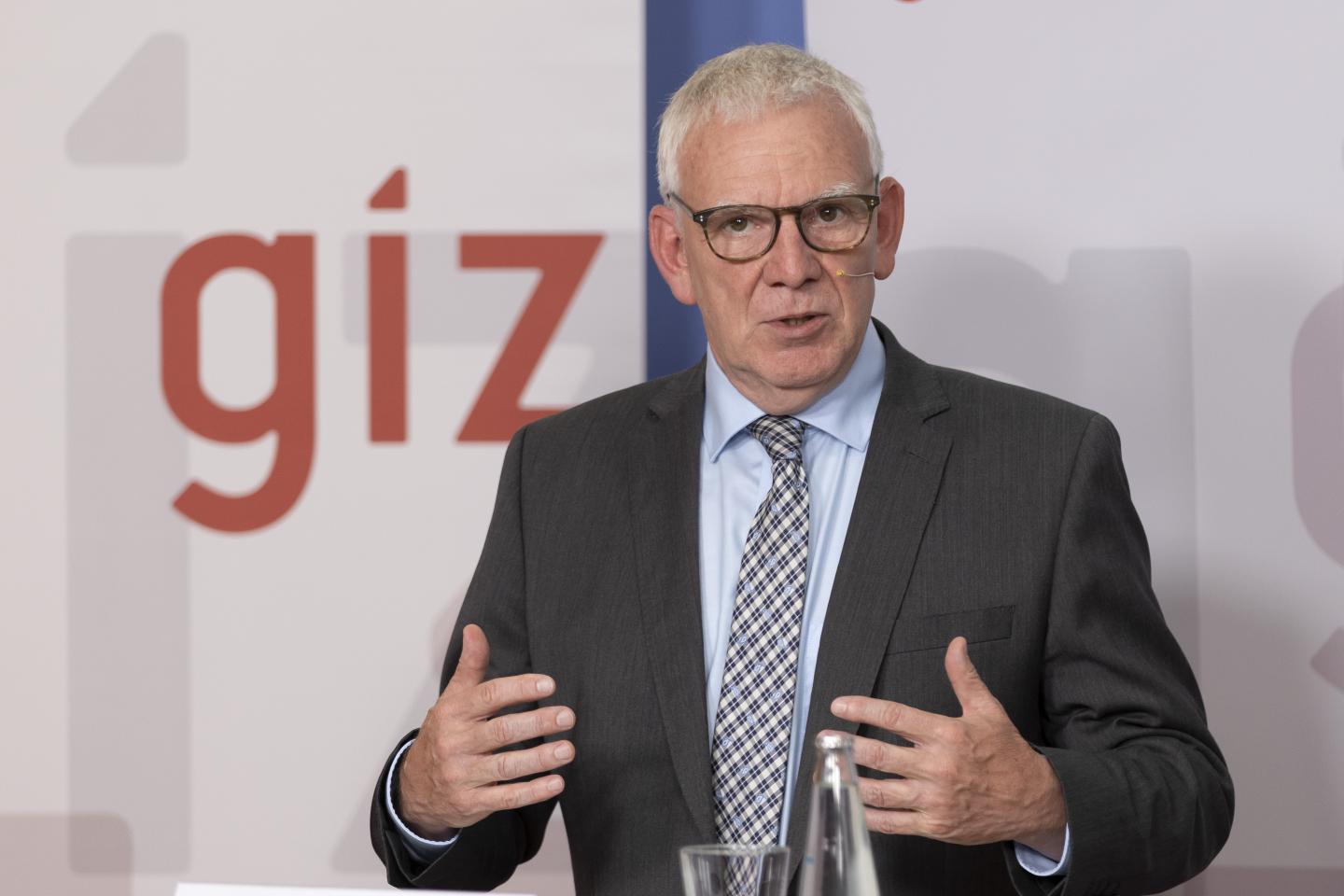 Jochen Flasbarth during a speech in front of a GIZ banner.