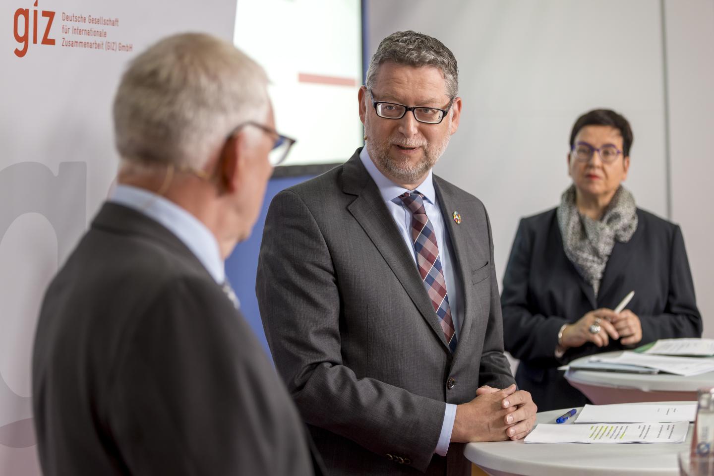 Jochen Flasbarth, Thorsten Schäfer-Gümbel and Ute Schaeffer photographed from a close perspective during a presentation.