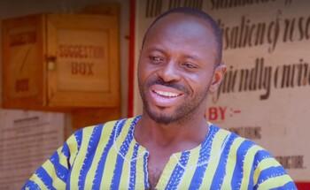 Portrait photo of a man in front of posters.