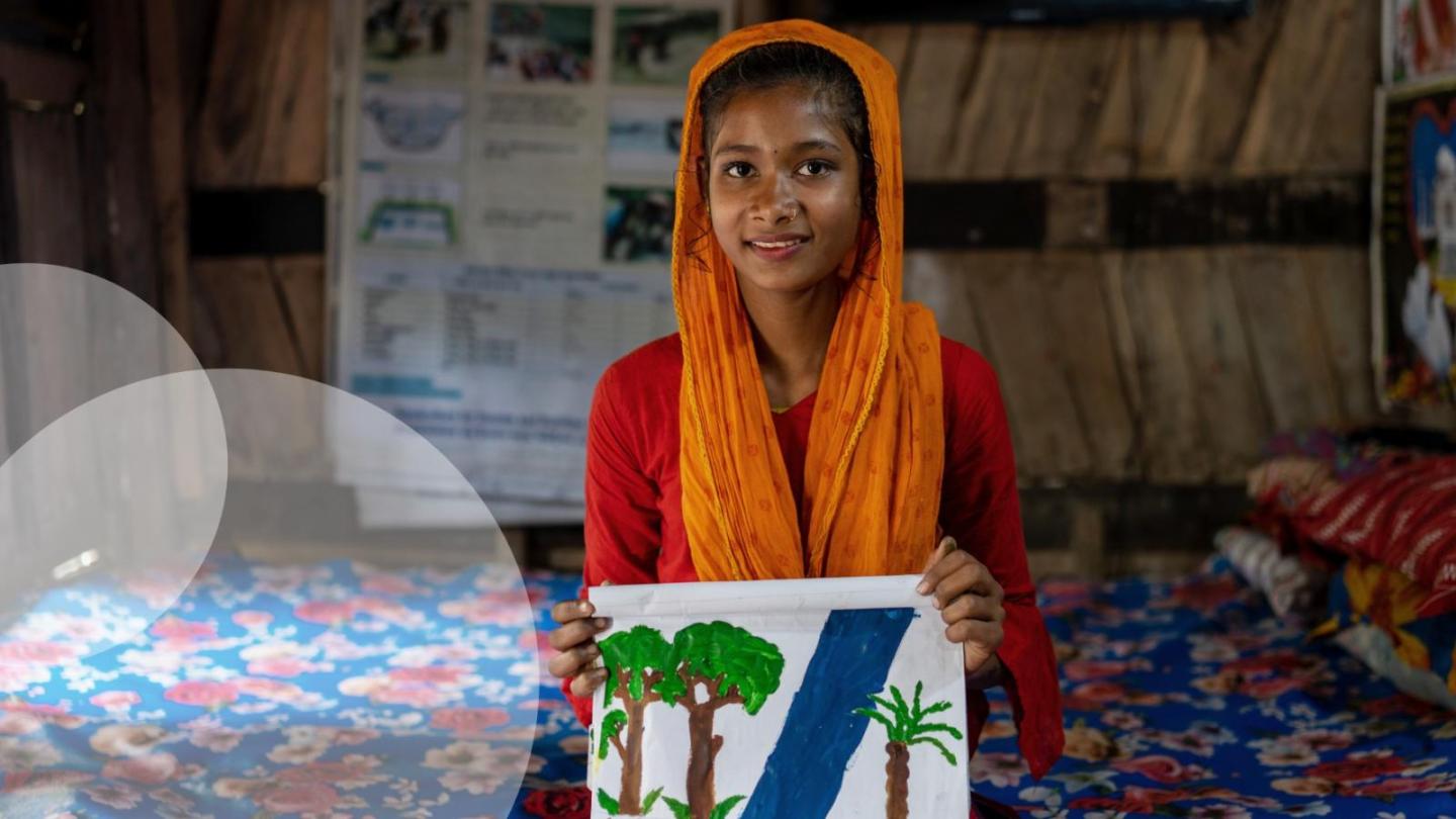 Girl holding up a picture she painted herself