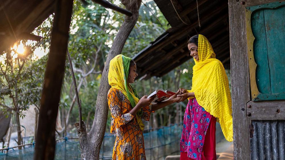 Zwei Frauen mit einem Buch in der Hand