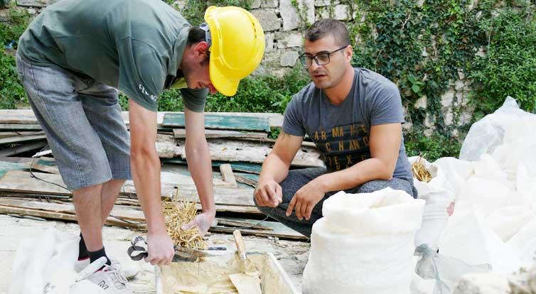 Trainer Elton Prendi (right) shows the future plasterers how to make plaster.