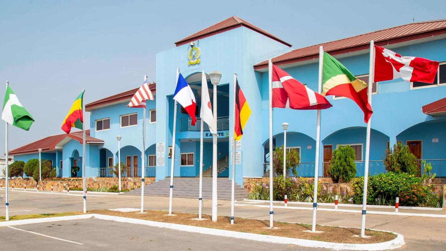 A light blue building with a staircase and several flags of different nations in front of it, including Germany, France, Nigeria and the USA.