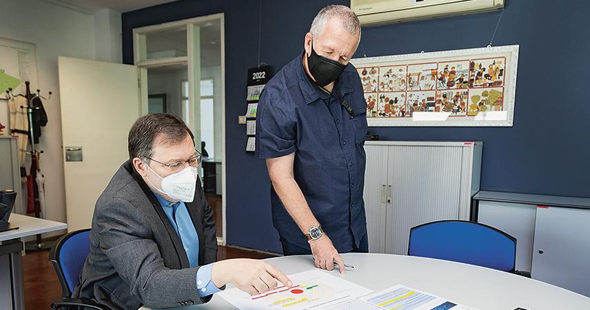 Like every morning, Peter Palesch meets briefly with the office management team.