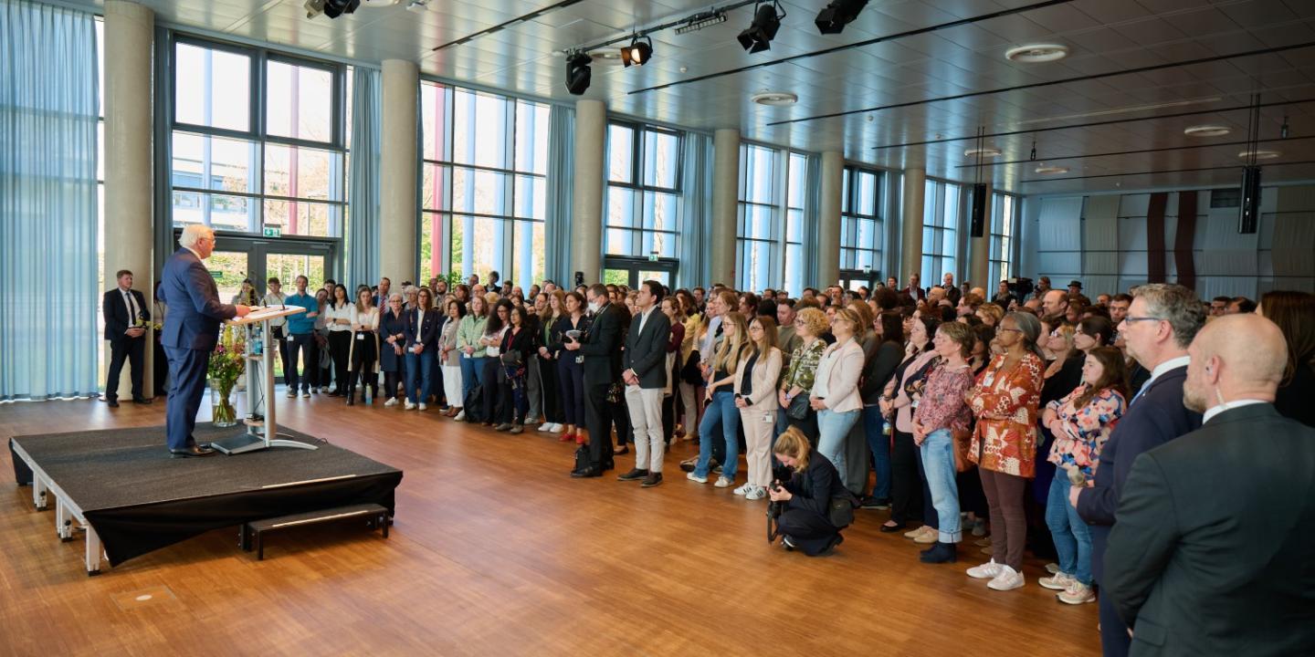 Frank-Walter Steinmeier addressing GIZ employees in the hall.