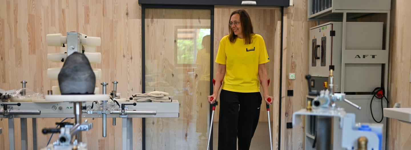 Eine Frau mit Gehhilfen schaut sich in der Werkstatt um