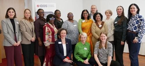 A group of people, most of them women, smile at the camera.