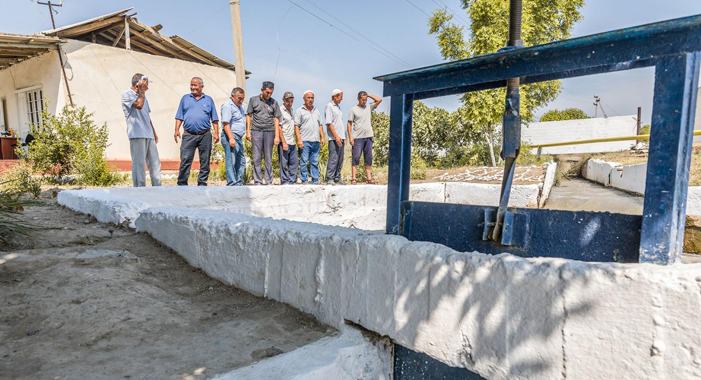 Solizhon Matmurodov (centre) inspects the waterworks with farmers.