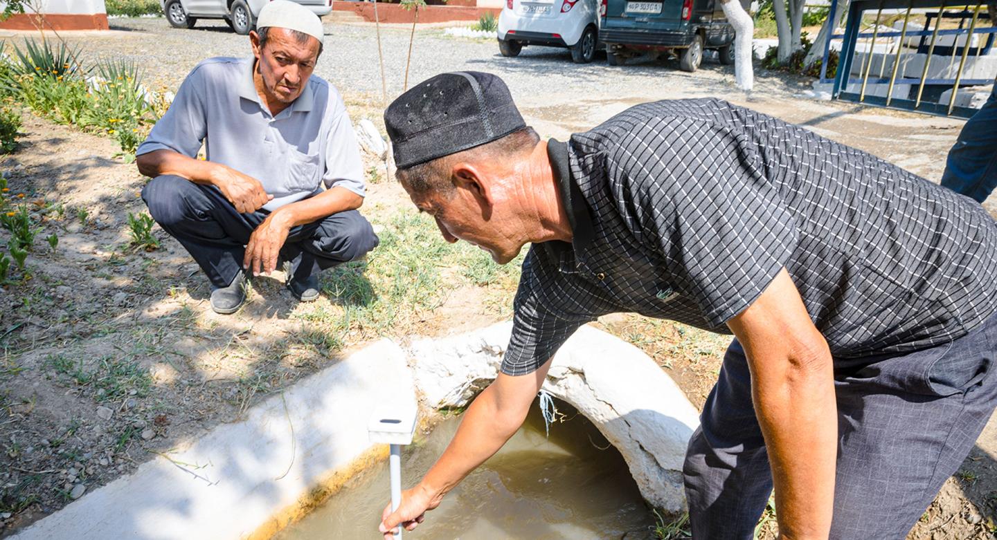 Engineer Matmurodov uses the Smart Stick to precisely control how much water flows through a canal in eastern Uzbekistan.
