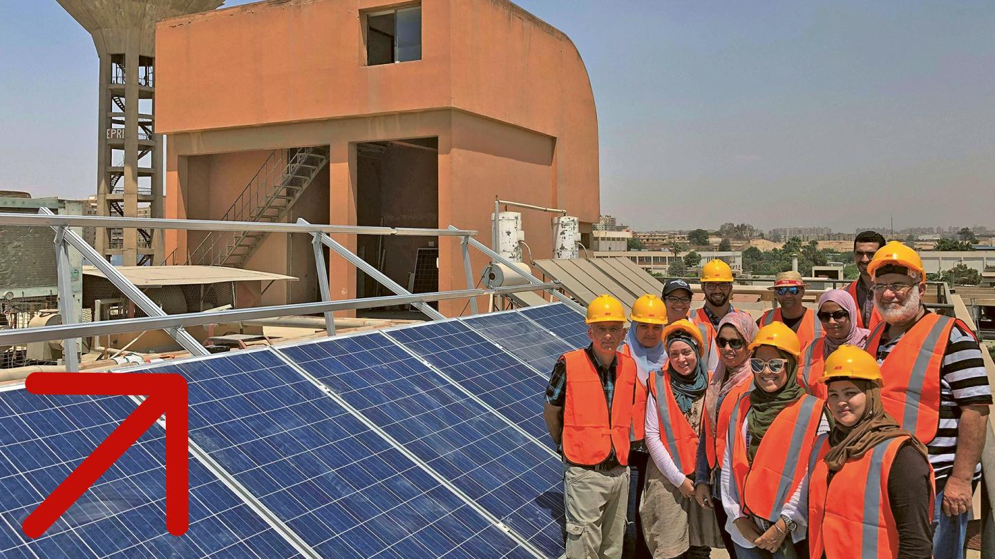 Mehrere Personen stehen vor einer Solarpanel