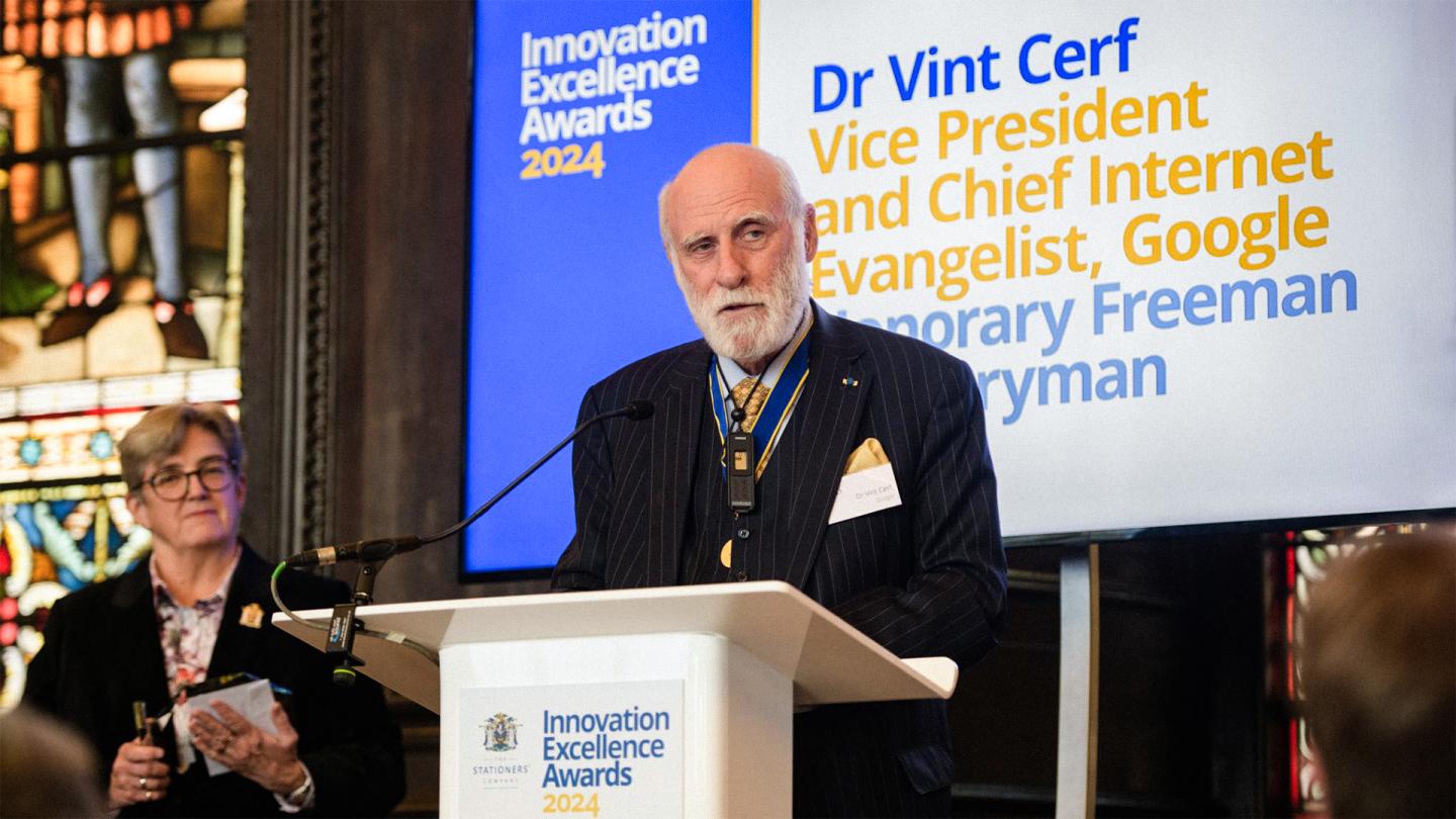 Dr. Vint Cerf speaks at the Innovation Excellence Awards 2024 at a podium, with his name and title displayed on a screen behind him.
