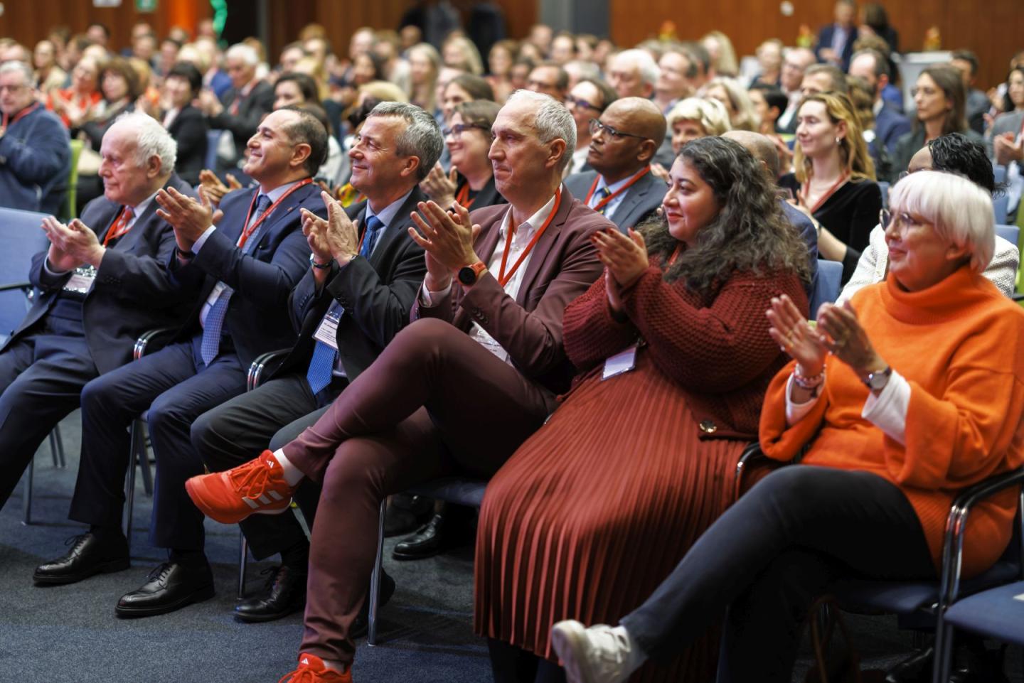 Several persons sitting in a row, clapping