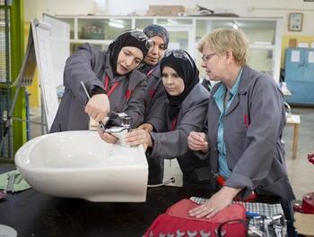 "Eine deutsche Klempnermeisterin unterstützt die Klempnerinnen in Ausbildung bei der Installation eines Wasserhahns." © GIZ / Thomas Imo/photothek.net