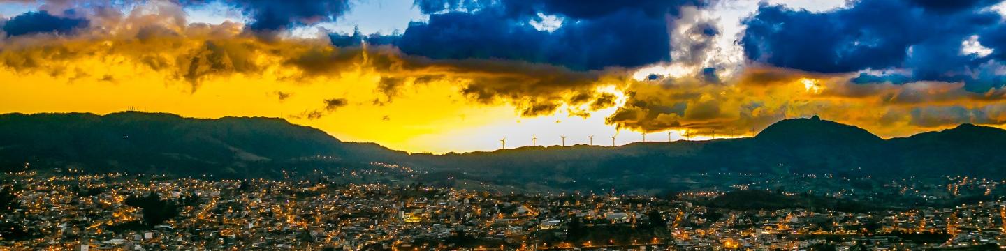 Lichter über den Dächern einer Stadt in der Dämmerung.