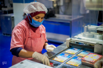 Eine Frau arbeitet an einem Fließband.