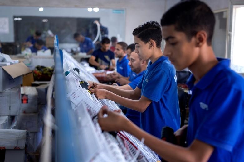 Young trainees work on a machine.