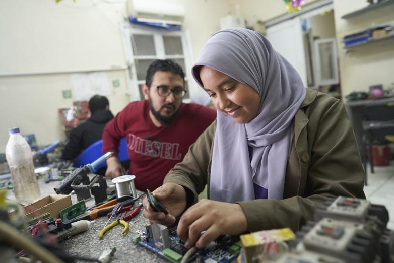 A young apprentice works in an electrical engineering workshop.