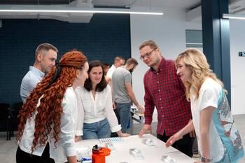 People stand around a table and exchange ideas.