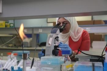 A woman at a microscope.