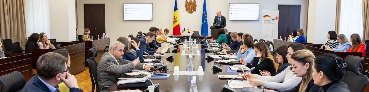 Ein Mann hält bei einem Austausch zwischen Projektvertreter*innen eine Rede.