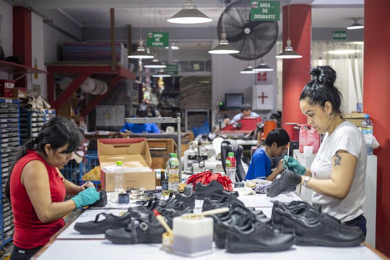 A man drilling into a wooden board in a furniture company.