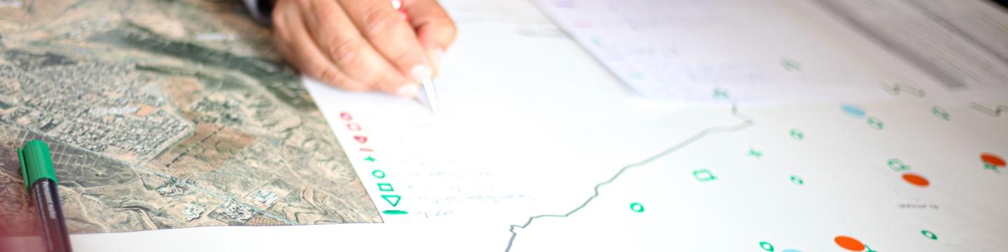 Eine Hand notiert etwas auf einer Karte.