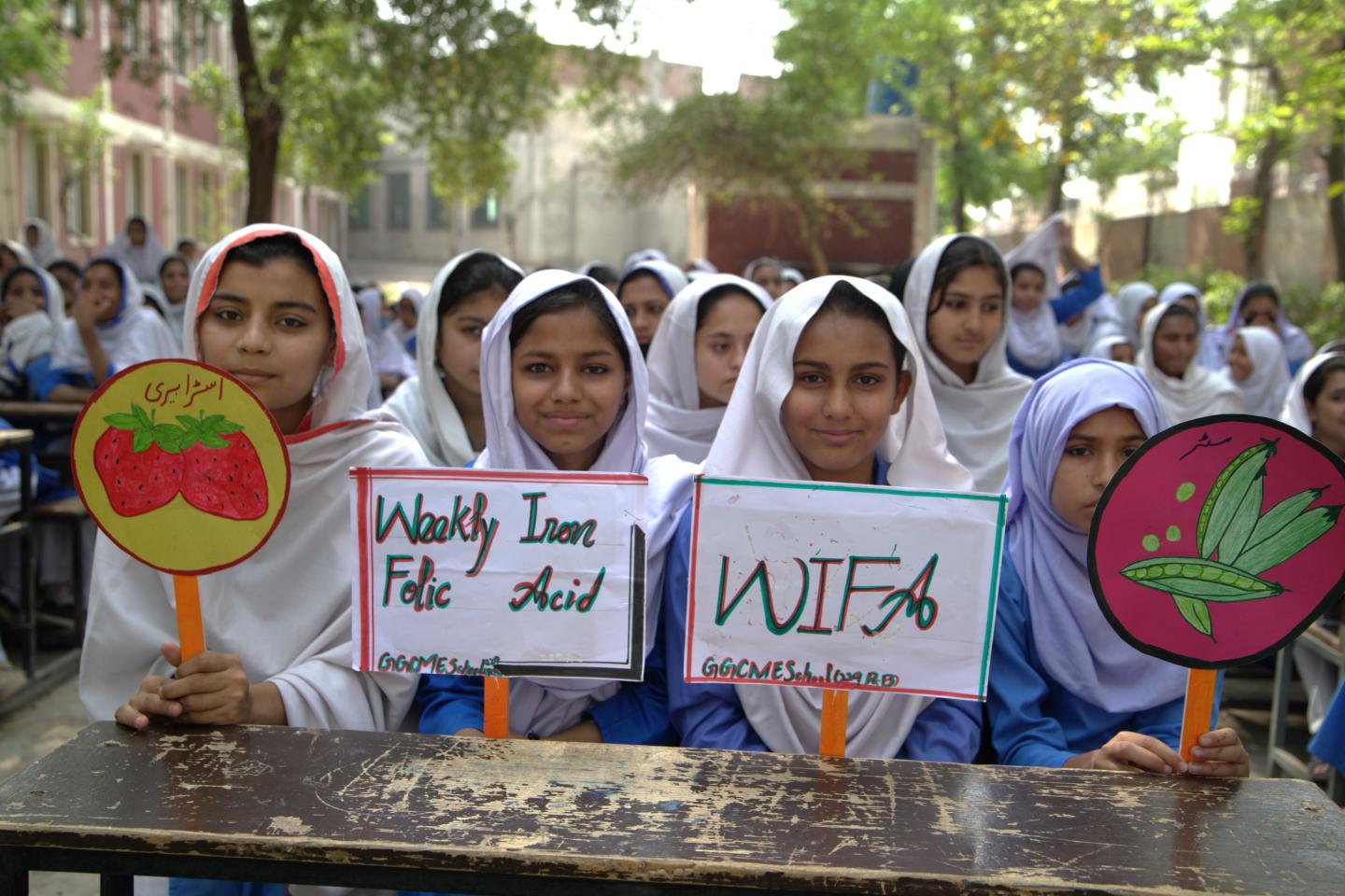 Eine Gruppe von Mädchen hält verschiedene Schilder in die Höhe und zeigt ihre Botschaften.