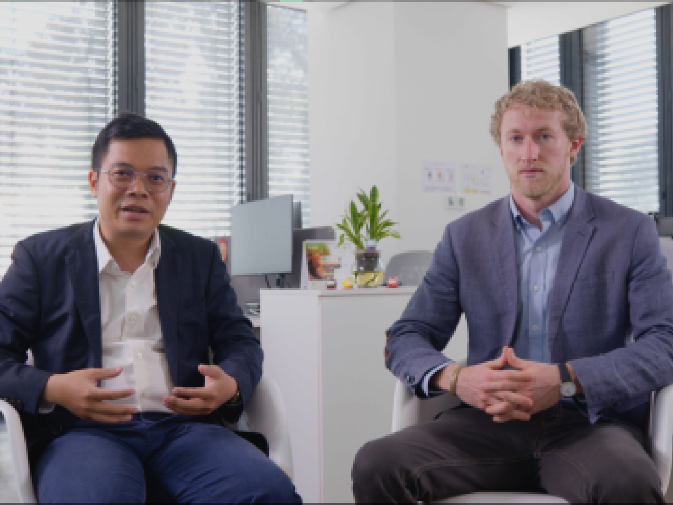 2 people sitting and 1 of them is talking