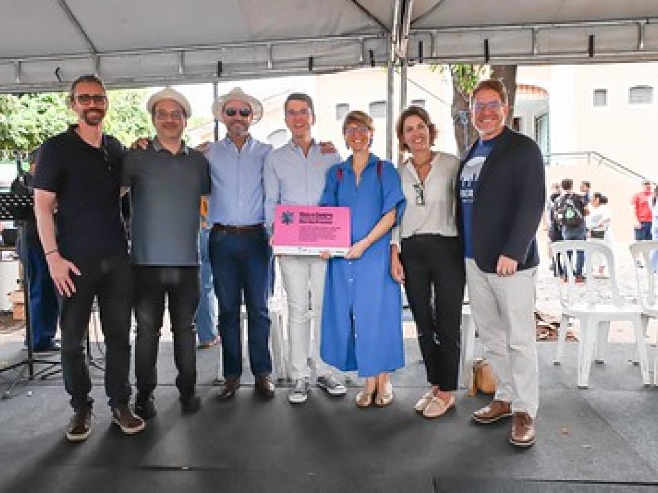 Gruppenfoto von Angehörigen der GIZ Brasilien, der Abteilung für die Strukturierung der städtischen und großstädtischen Entwicklung des Ministeriums für Städte, der Stadtverwaltung die die Bürgermeisterin von Uberaba auf dem städtischen Markt, zur Kamera gewandt.