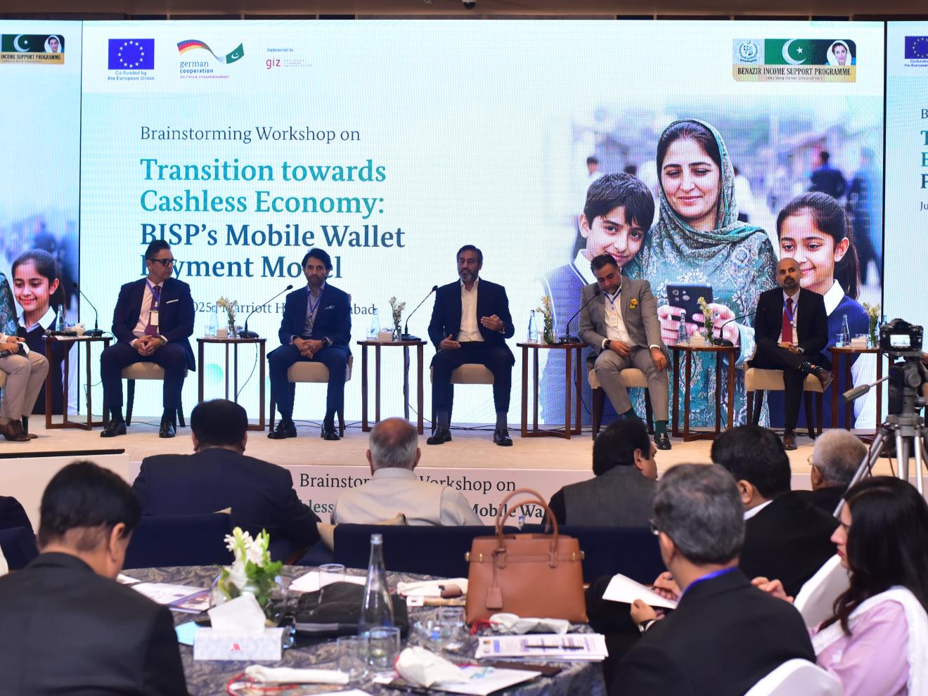 Panelists sitting on a stage during a panel discussion.