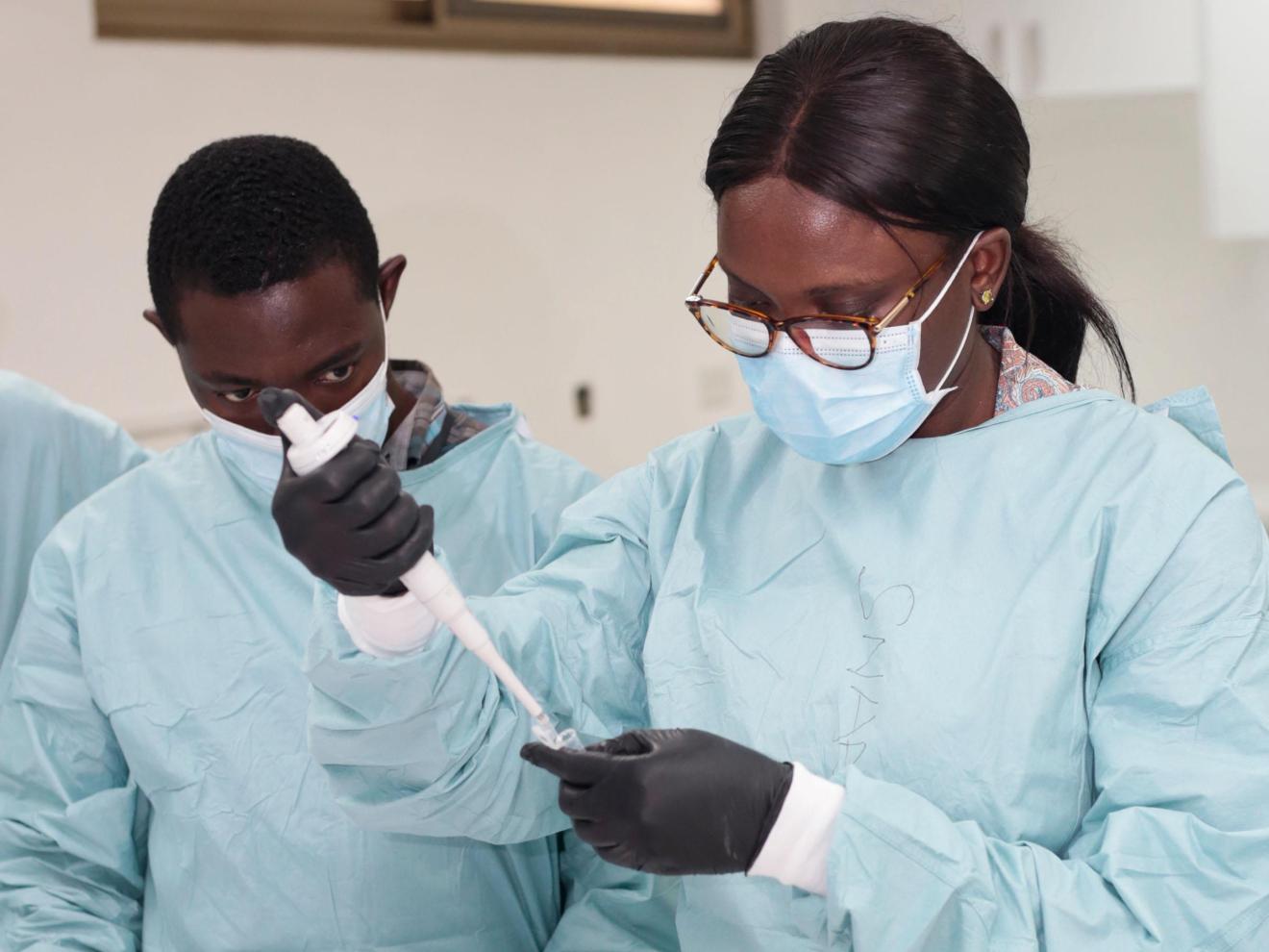 Two participants in a SEEG mission in Ghana prepare samples for sequencing SAR-CoV-2.