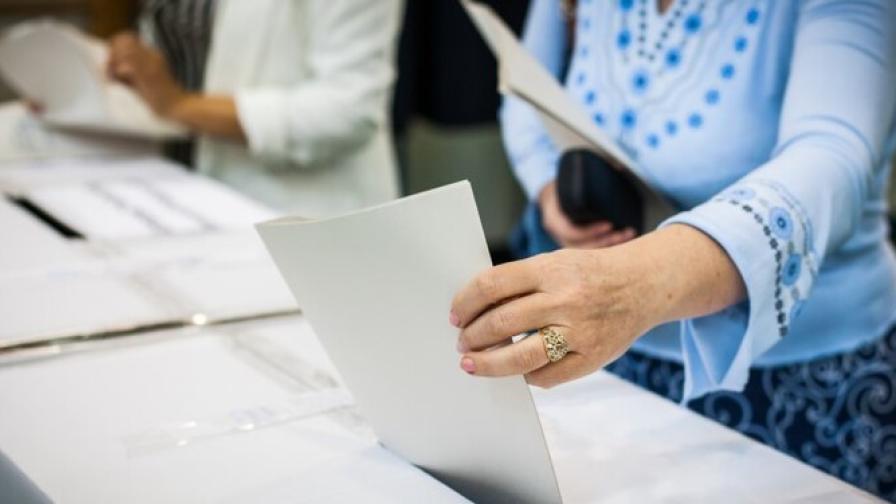A person is casting a paper ballot during elections.