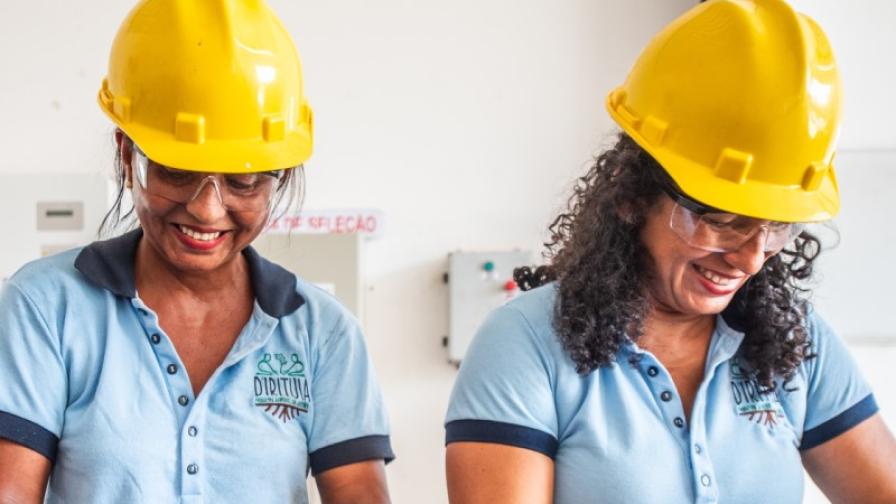 Two women in hard hats selecting seeds.