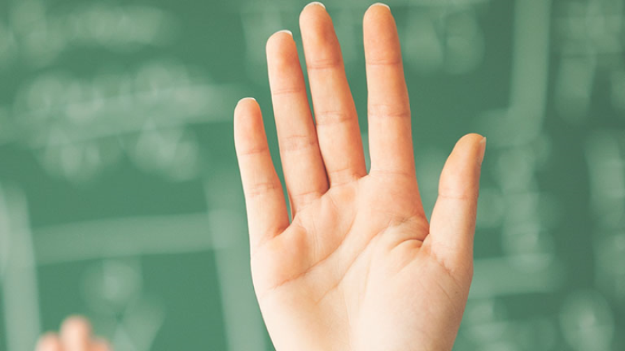 Hands raised in a message in front of a blackboard.