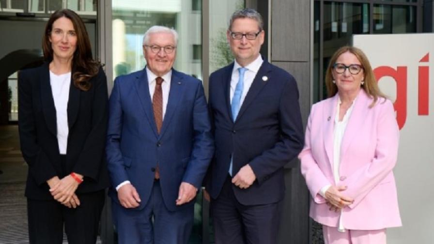 Bundespräsident Frank-Walter Steinmeier mit Anna Sophie Herken, Thorsten Schäfer-Gümbel und Ingrid-Gabriela Hoven vor einem Schild mit GIZ-Logo.