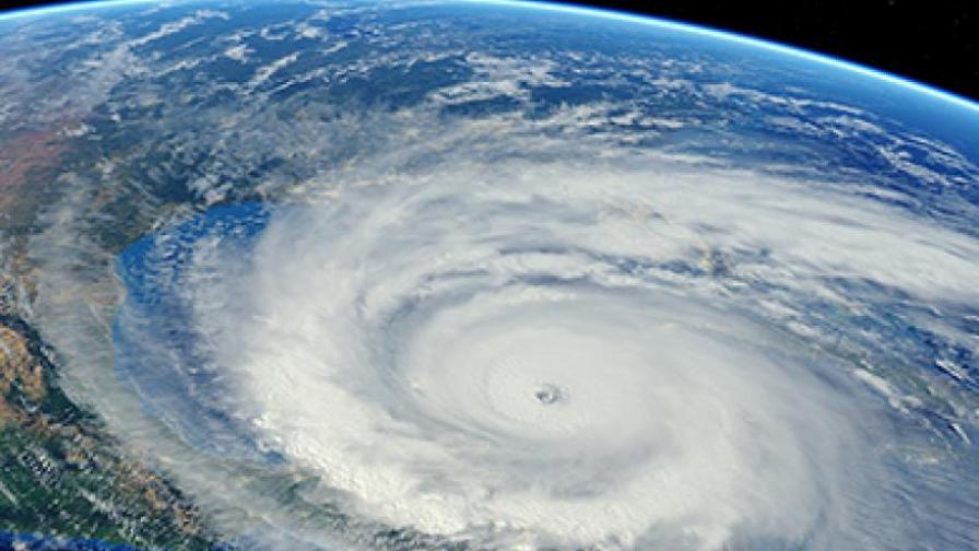 Satellitenfoto eines Hurrikans, der sich über den Ozean einem Kontinent nähert. Der Hintergrund ist schwarz und zeigt die Erde aus der Weltraumperspektive