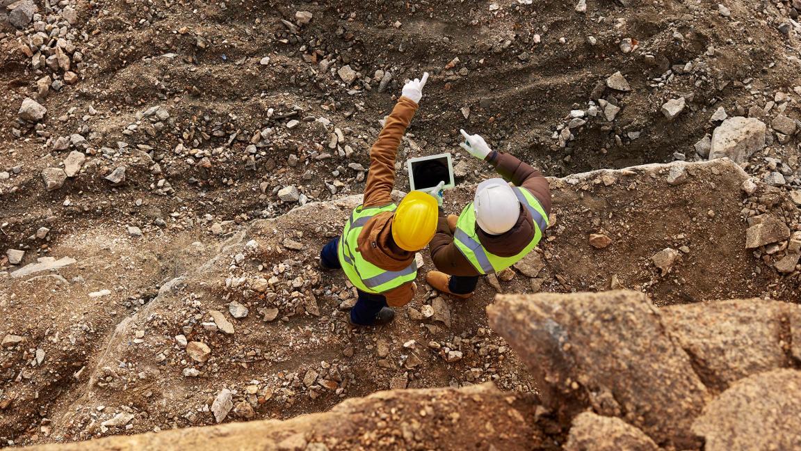 Zwei Bauarbeiter mit Helmen führen eine Inspektion durch