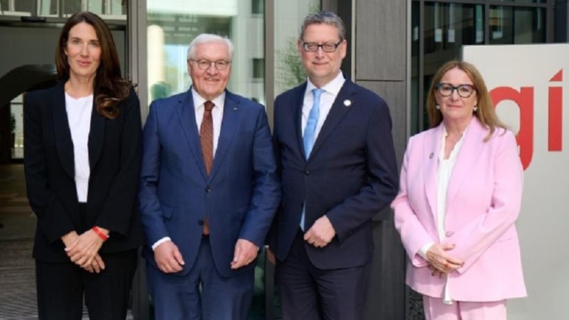 Bundespräsident Frank-Walter Steinmeier mit Anna Sophie Herken, Thorsten Schäfer-Gümbel und Ingrid-Gabriela Hoven vor einem Schild mit GIZ-Logo.