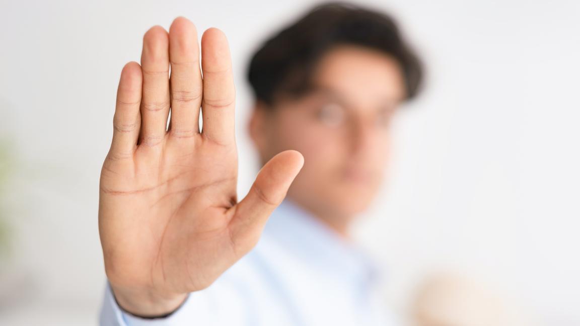 Eine Person hält der Kamera die flache Handfläche entgegen.