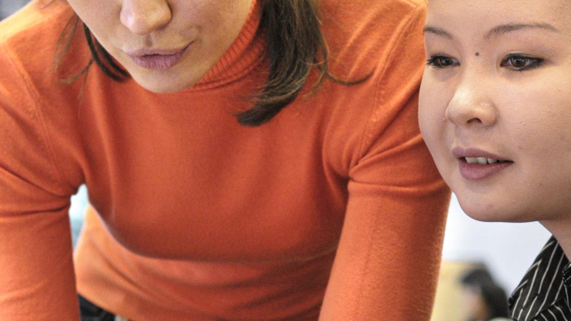 Zwei Frauen besprechen etwas vor einem Bildschirm