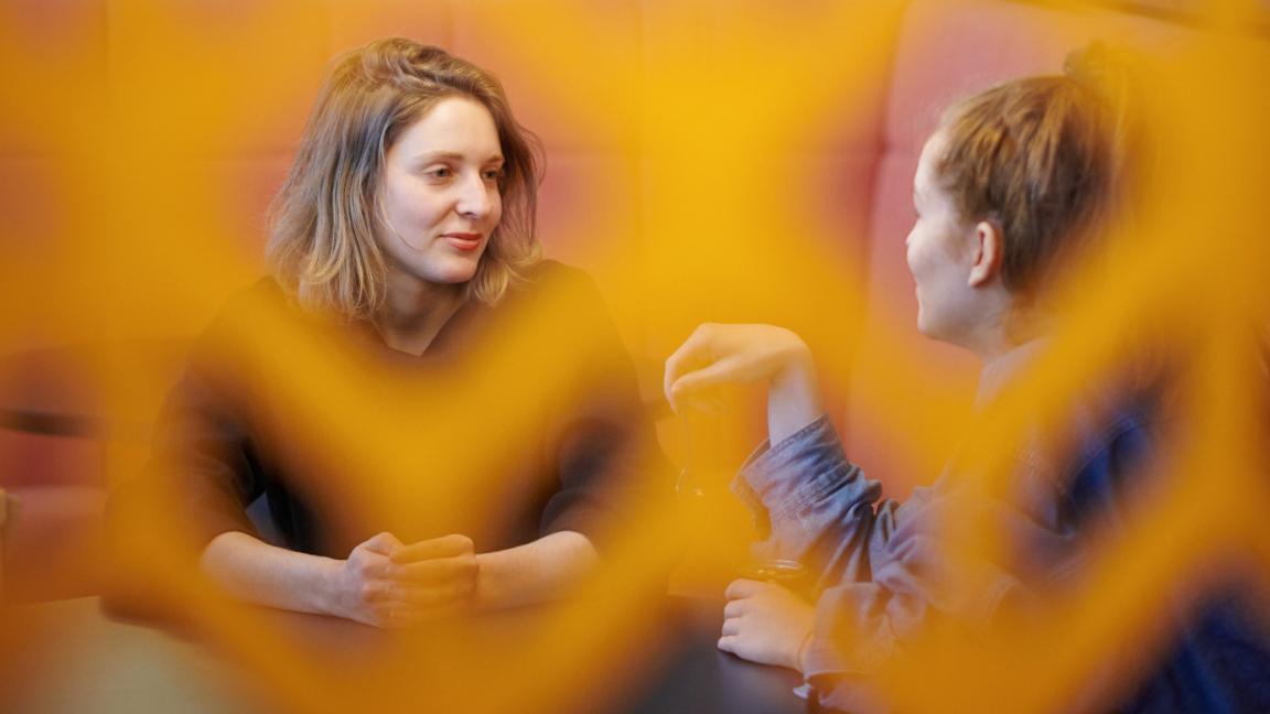 A young woman and a young man putting sticky notes on a glass wall