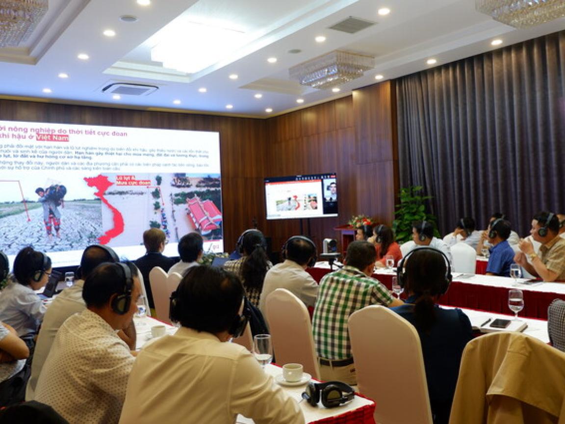 People sitting at tables listening to a presentation